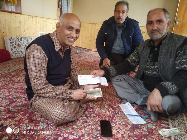 Post office workers handing over the pension to elderly people. 