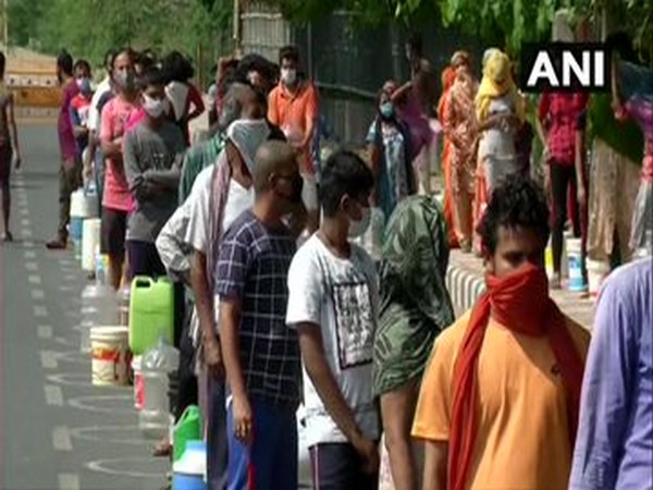 People in Chilla village line up to collect drinking water from DJB tankers amid coronaLockdown. Photo/ANI