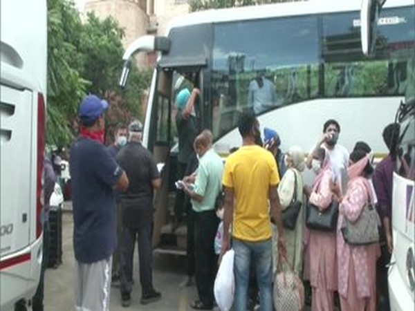 The US nationals boarding the buses to Delhi. Photo/ANI