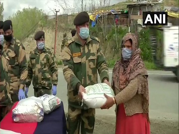 BSF personnel distribute ration to daily wage labourers in Pampore, Pulwama on Wednesday (Photo/ANI) 