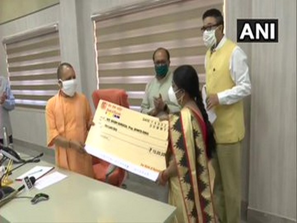 Uttar Pradesh Chief Minister Yogi Adityanath hands over cheques to people involved in MSME sector. Photo/ANI