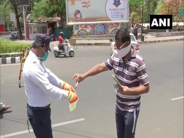 A traffic violator sanitising currency notes before giving it to the police personnel in Bhopal.