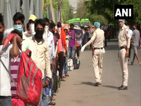 Migrant workers queue outside Lajpat Nagar police station to board buses. 