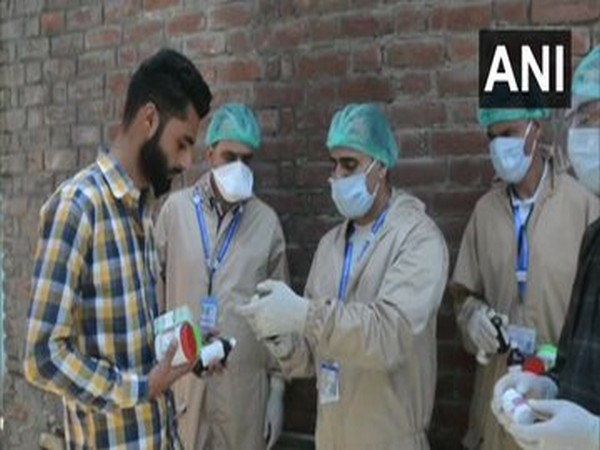 Officials of Jammu and Kashmir AYUSH Department distributed immunity booster medicines to the residents in red zones (Photo/ANI)