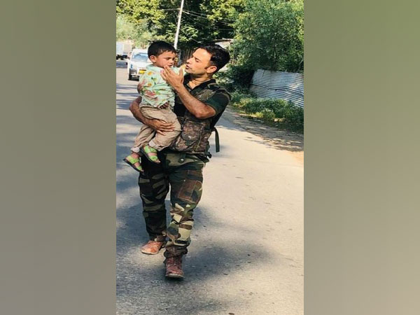 Police carrying the 3-year-old boy to safety in J-K's Sopore.