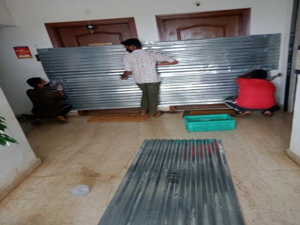 BBMP worker removing steel sheets from the doors of sealed flats
