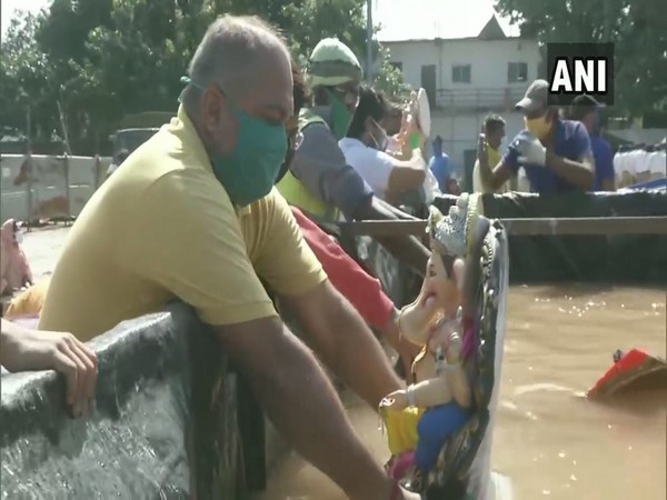 A man carries out Ganesh Visarjan in Nagpur in an artificial pond. (Photo/ANI)