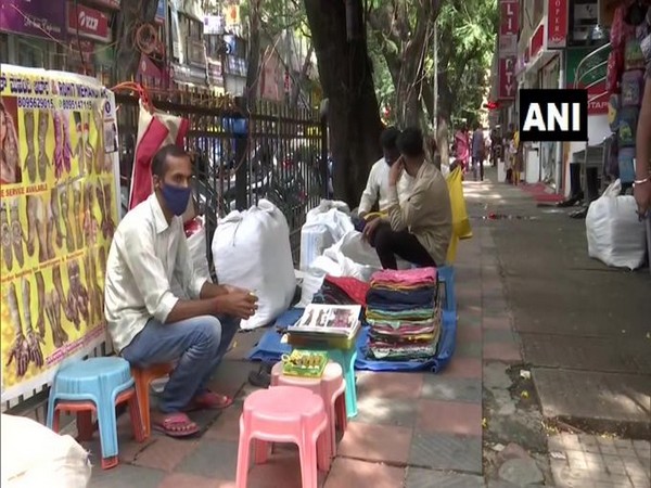 Durgesh Kumar, a henna artist in Bangalore waits on the pavement for customers. (Photo/ANI)