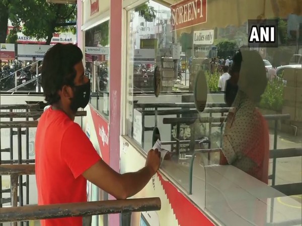 A customer purchasing a ticket in a Madurai movie theatre. (Photo/ANI)