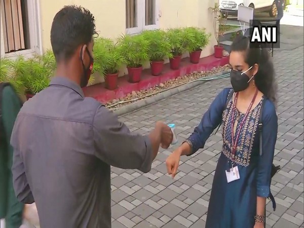 A student gets her temperature checked before entering the college campus. (Photo/ANI)