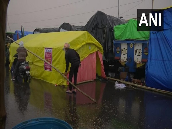 Farmers at Gazipur (Delhi-UP border) setting up tents amid the rain. (Photo/ANI)