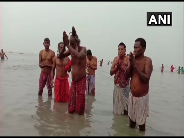 Devotees and hermits take a dip in the Gangasagar river in West Bengal. (Photo/ANI)