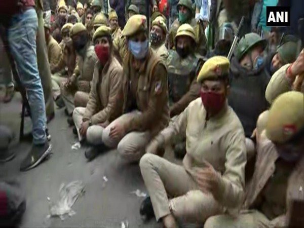 Police personnel sit on road in Nangloi to block farmers' tractor rally. [Photo/ANI]