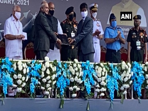 Defence Minister Rajnath Singh presented the Tejas model to HAL chief R Madhavan at the opening ceremony of the Aero India 2021. Photo/ANI