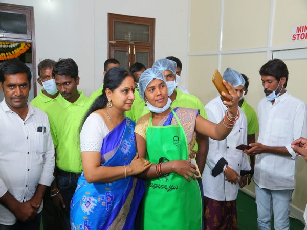 TRS MLC Kavitha Kalvakuntla poses for a selfie with a worker at the inauguration of a free food centre in Telangana's Nizamabad.  