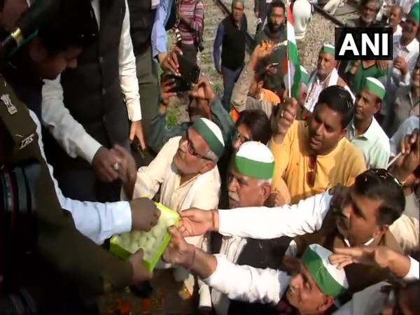 Farmers distributing sweets at Modinagar during Rail roko (Photo/ANI)
