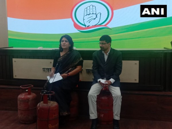 Congress leaders Supriya Shirnate and Vineet Punia sitting on LPG cylinders to address media on Thursday. (Photo/ANI)