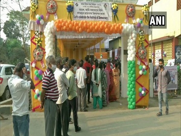 Voters stand in queue outside a polling booth in Dibrugarh. (Photo/ANI)