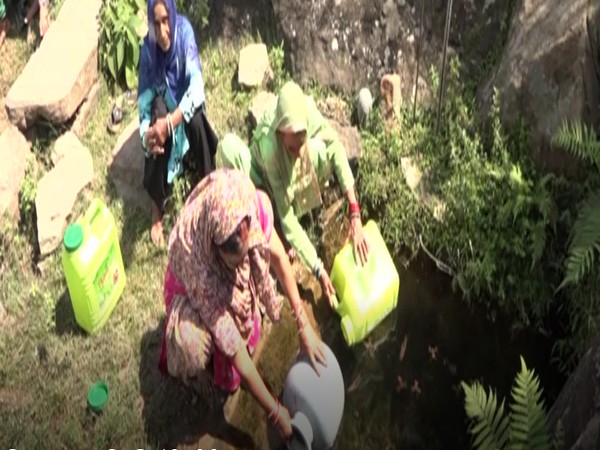 Women are fetching water from a pit in JK's Udhampur. (Photo/ANI)