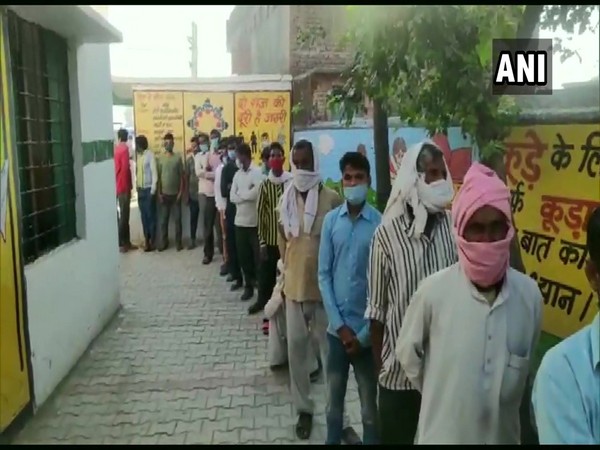 Voters queue up at Devapur Primary School in Moradabad to cast their votes for the third phase of UP Panchayat polls on Monday. [Photo/ANI]