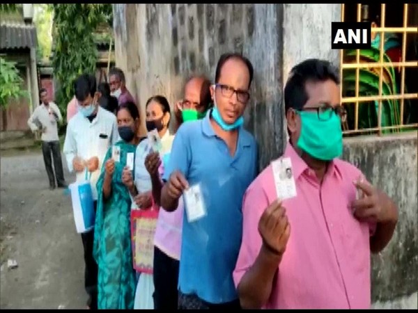 Voters queue up outside a polling booth in North Parganas on Saturday. (Photo/ANI)