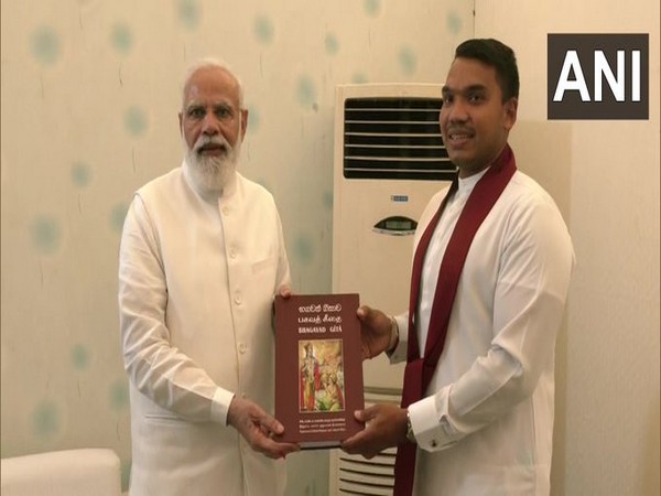 Sri Lankan Minister Namal Rajapaksa met PM Modi and gifted him Sinhala version of Bhagavad Gita (Photo:Twitter/ANI)