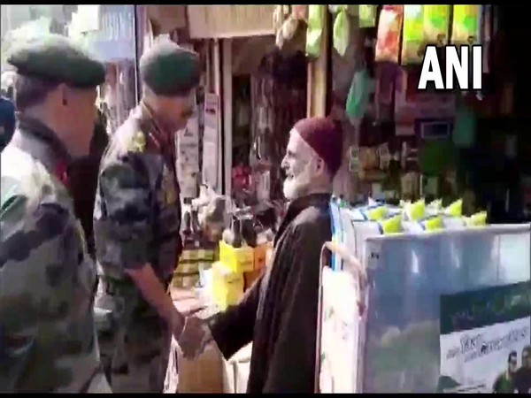 Army officers distributing sweets among people in Shopian on Wednesday. (Photo/ANI)