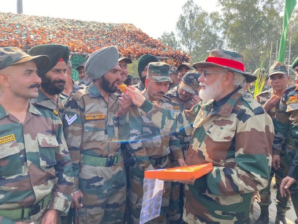 Prime Minister Narendra Modi distributing sweets to soldiers. (Photo/ANI)