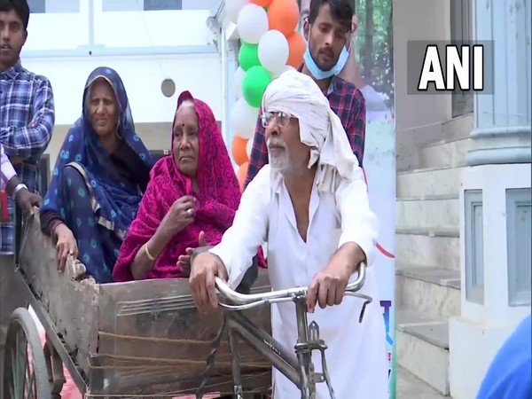 Senior citizen pulls cart carrying women to polling booth in UP. (Photo/ANI)