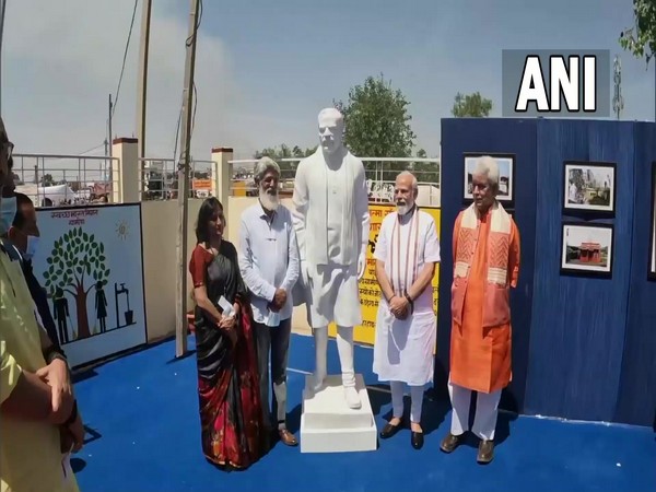 Prime Minister Narendra Modi meets a sculptor who made his statue at the INTACH photo gallery set up at Palli village in Samba district of Jammu. (Pic credit: DD News)