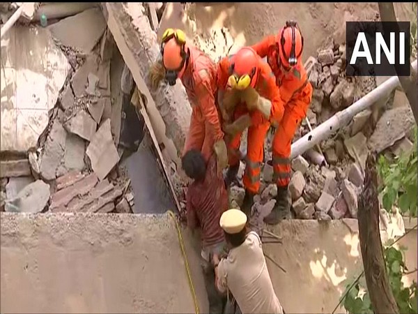 NDRF personnel rescues a man from the debris of Satya Niketan building (Photo/ANI)
