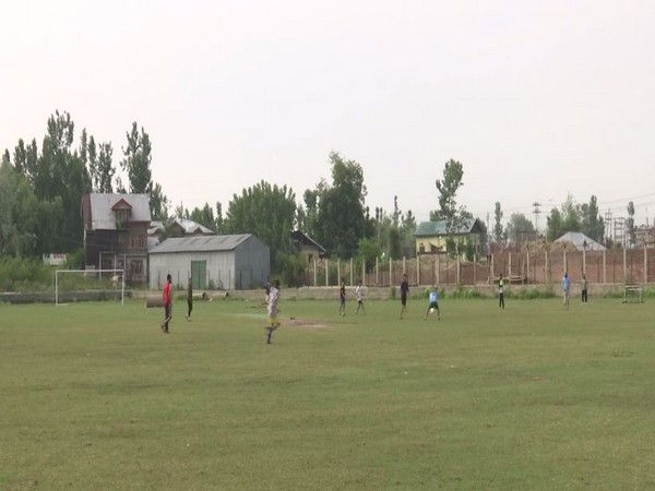 Locals playing football in the playground in Srinagar. (Photo/ANI)