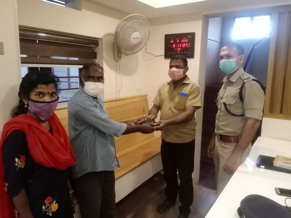 Police officials handing over the wallet to its owner.