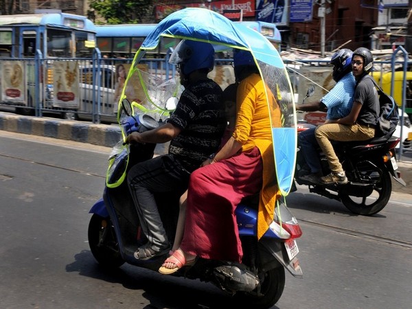 Bikers start using China made two-wheeler cover to protect themselves from the heat on a hot day in Kolkata on Friday. 