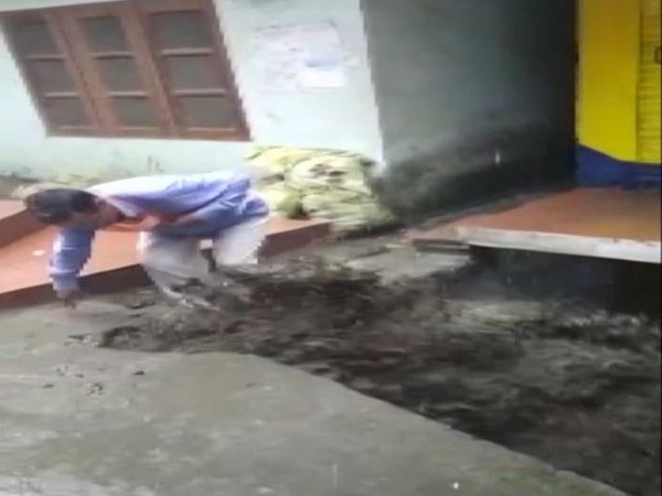 Locals attempt to rescue people stuck inside a shop due to an overflowing nullah in Mandi, Himachal Pradesh. 
