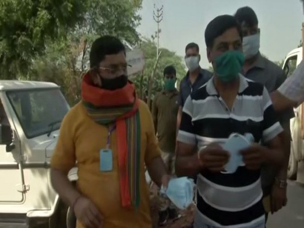 Mayor of Hathras Ashish Sharma distributes mask in Bulgadhi village on Tuesday. Photo/ANI
