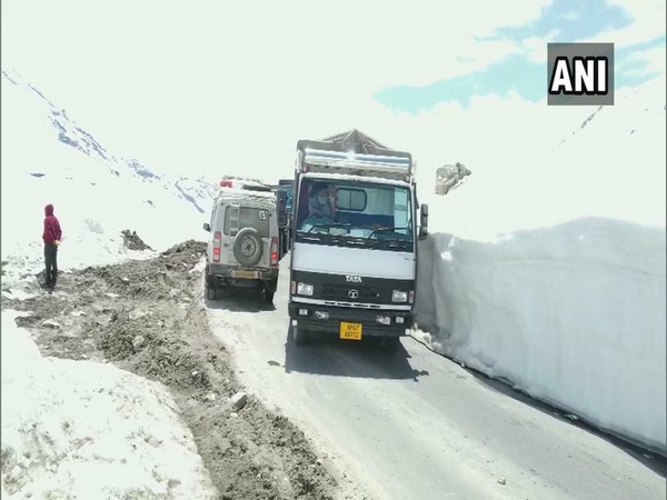 Truck drivers drive through snow-clad Rohtang Pass to deliver essential goods in Himachal Pradesh on Wednesday. Photo/ANI