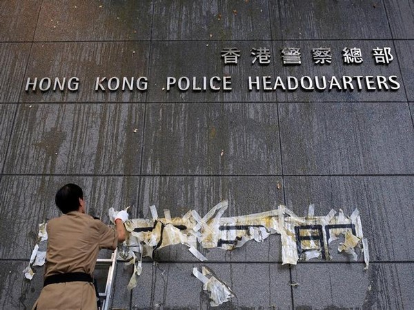 A staff tries to clean off the marks from thrown eggs and anti-extradition graffiti on the walls of the Hong Kong Police headquarters here on Saturday