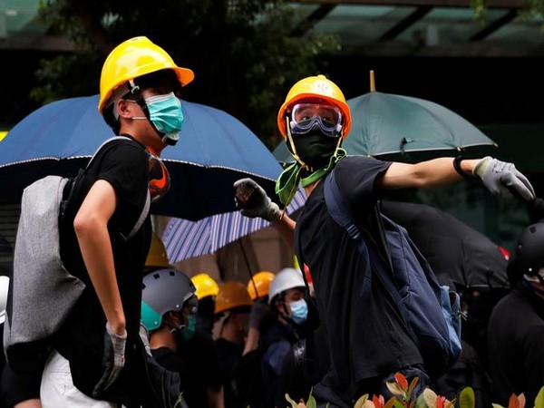 An anti-extradition bill protester throws a stone at a police station in Tseung Kwan O residential district, in Hong Kong on Sunday