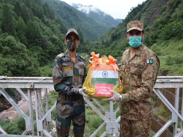 Troops of BSF and Pakistan Rangers exchangimng sweets on the occasion of Eid-Ul-Adha, at the Indo-Pak Border in Jammu.