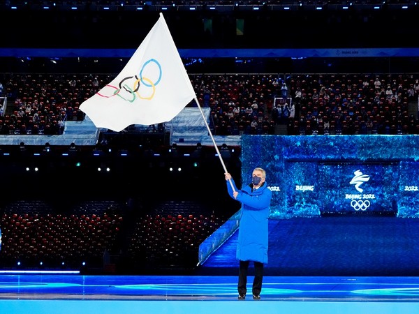 IOC president Thomas Bach waves the Olympic flag during Beijing Winter Olympics closing ceremony. (Photo Credit - Reuters)