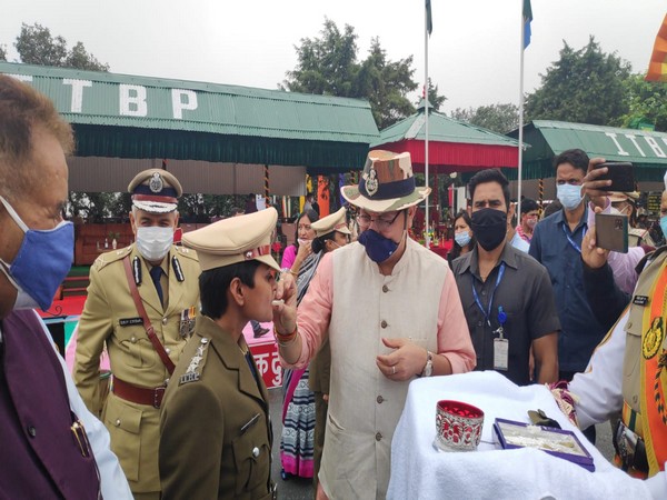 Uttarakhand Chief Minister Pushkar Singh Dhami giving sweets to one of the officers at ITBP in Mussoorie on Sunday (ANI Photo)