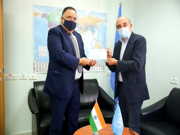 India's representative to Palestine, Sunil Kumar (L) handing over the check for UN Relief and Works Agency for Palestine Refugees in Near East (UNRWA).