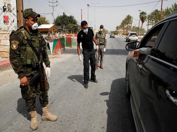 Members of Palestinian security forces wear masks as they check people's identity amid coronavirus precautions, in Jericho, in the Israeli-occupied West Bank