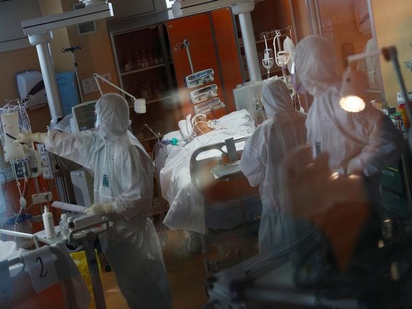 Medical workers in protective suits treat patient suffering from coronavirus in ICU at a hospital in Rome dedicated to treating COVID-19. 