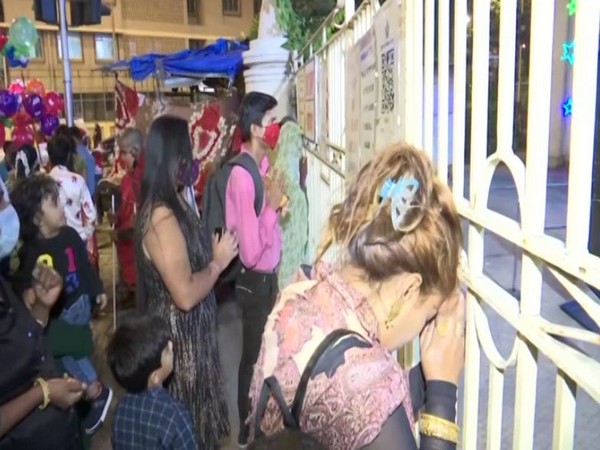 People pffering prayers from the gate of a church in Mumbai (Photo/ANI)