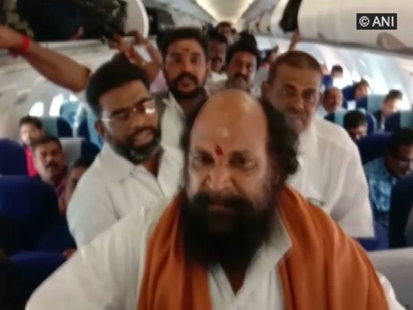 K A Murugan and his supporters raise slogans inside the flight heading to Madurai on Saturday.