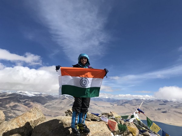 Kaamya Karthikeyan holding an Indian flag at the top of Ladakh's Mt Mentok Kangri II 