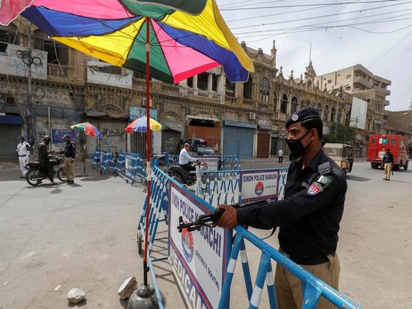 A police officer guards a check-post set up with barriers during a partial lockdown in Karachi.