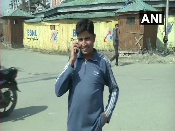 A local in Srinagar talking on the phone after postpaid mobile services were restored in Jammu and Kashmir on Monday.